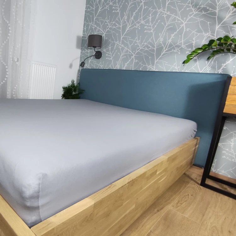 Prześcieradło z gumką 200x220 na łóżku szare