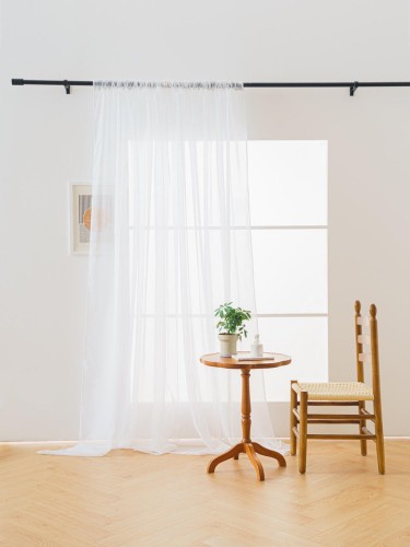 Elegancka biała firanka woalowa 145x250 cm delikatnie rozpraszająca światło w nowoczesnym salonie.