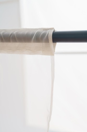 Firanka woalowa o wymiarach 145x250 cm, zawieszona na taśmie z tunelowym montażem, dla łatwej instalacji.