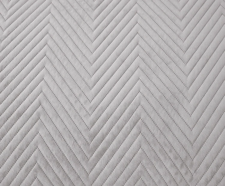 Komfortowa narzuta 200x220 w odcieniu jasnoszarego, wykończona matową tkaniną na podwójnym łóżku.
